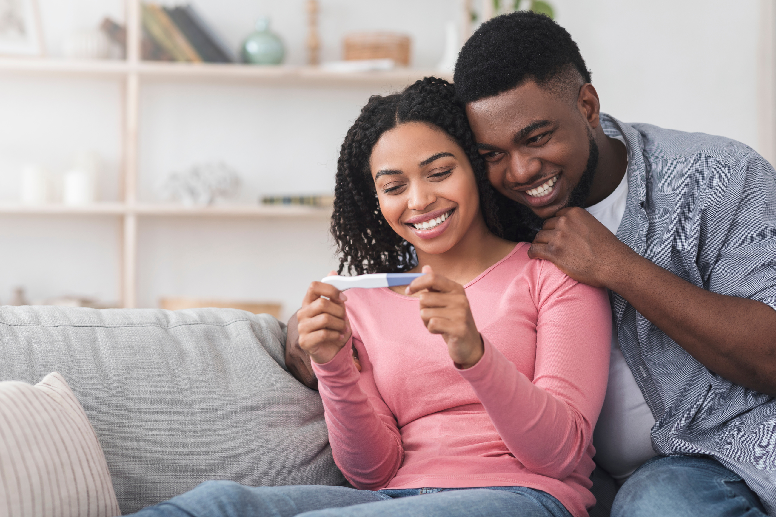 Married black couple happy with positive results of pregnancy test